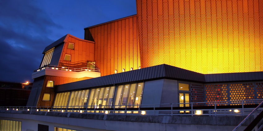 Berliner Philharmonie building illuminated at night with big halls coloured yellow
