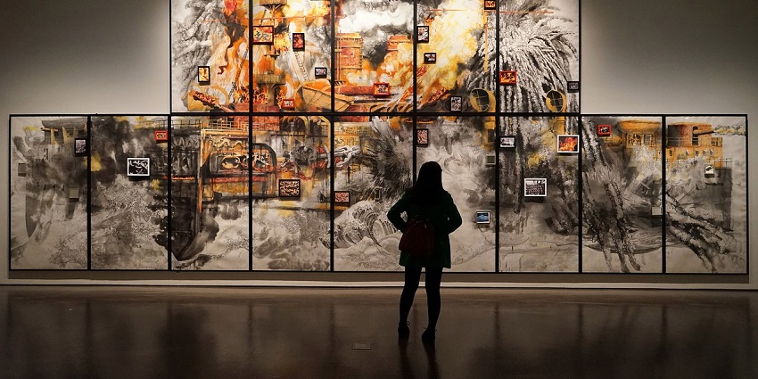 An image of a girl admiring art in a museum must be like the Beatles Museum in Liverpool.