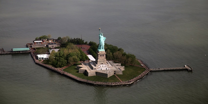 Aerial view of statue of Liberty and the base fort surrounded clear blue water