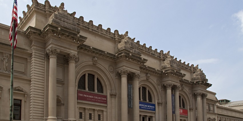 An image showing the majestic columns and grand details of the Met Museum's front.