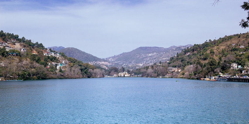 A panoramic view of Bhimtal Lake from Aquarium Island Cafe, showcasing serene waters and lush hills