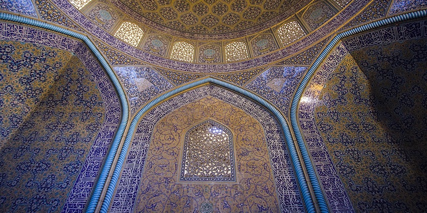 Ceiling of one of the mosques in Malta with a unique partially fading design and warm lights hanging.