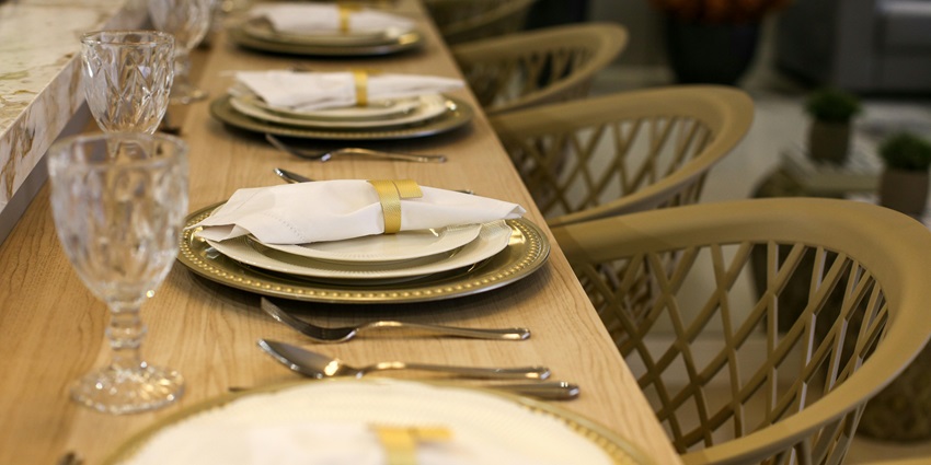 A picture of a well-furnished restaurant table setting with white plates, and glasses.