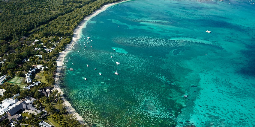 A view of Blue Bay Beach, on whose shore beach chairs are present with the umbrella.
