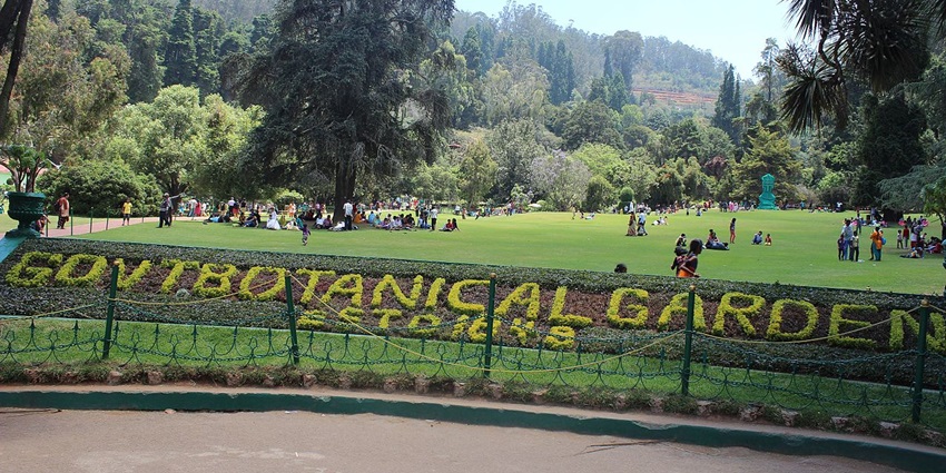 The front view of the Government Botanical Gardens in Ooty, filled with tourists, as mentioned in the Ooty travel guide.