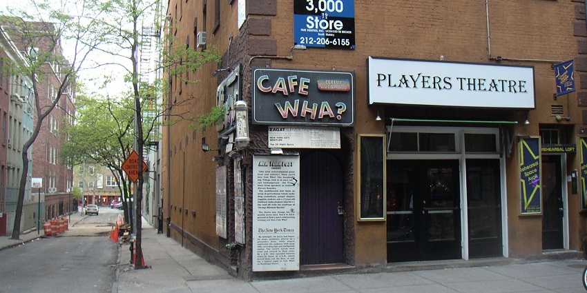 Cafe Wha in New York, with a street view showcasing its iconic sign and vibrant exterior.
