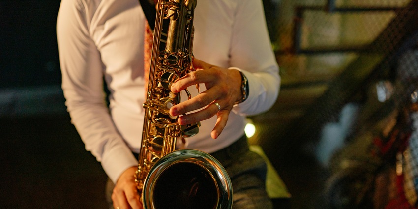 Musicians performing at a jazz club with a close-up of a person playing saxophone.