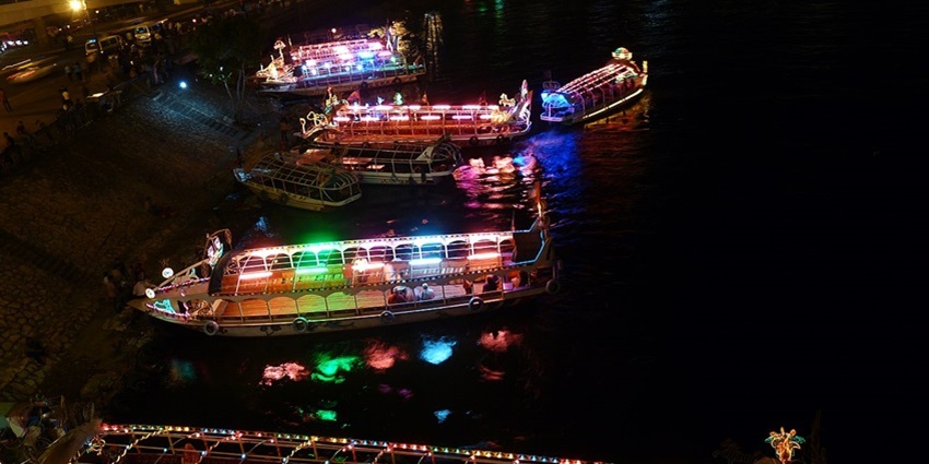 Multiple sailboats decorated with colourful lights, a spot to enjoy Egypt nightlife.