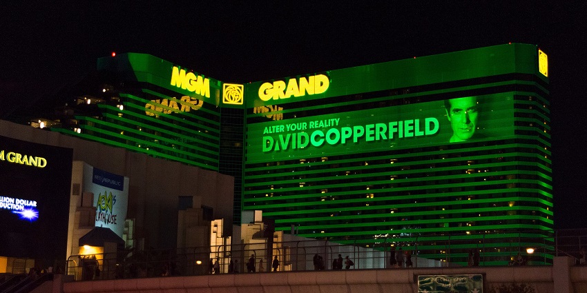 MGM Grand at night with bright yellow signage of MGM Grand on green-lighted building