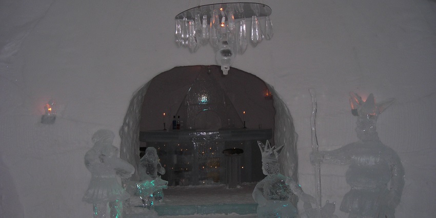 Inside the Alta Igloo Hotel with carved ice sculptures at the entrance of the bar