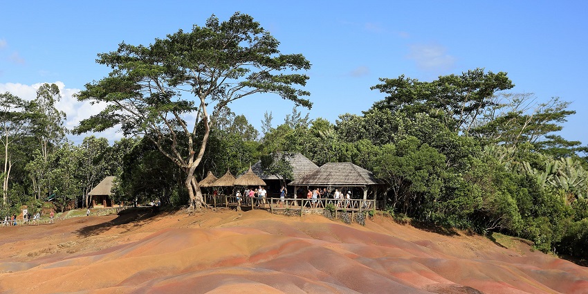 Charamel seven-coloured earth with different-coloured ground and huts with people inside.