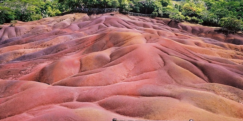 Chamarel village and its seven coloured earths of red and brown with greenery next to it.