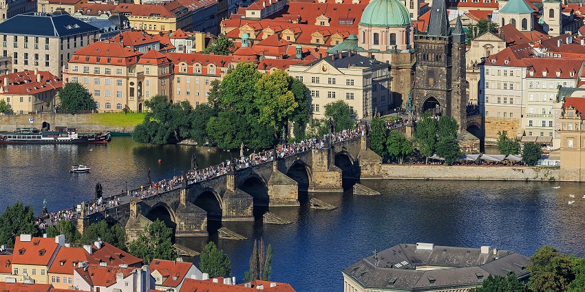 A view of an iconic Charles Bridge with Baroque statues and views of the Vltava River.