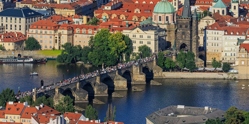 A picture of a couple walking across Charles Bridge on Valentine's Day in the Czech Republic.