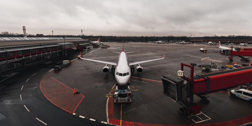 An airplane on the runway at an airport during sunset primarily used for charter flights.