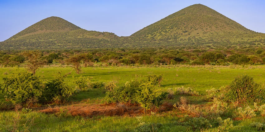 A panoramic view of the two hills located in a national park surrounded by greenery.