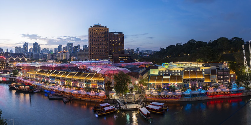 A nighttime view of illuminated Clarke Quay, a place to visit on the Singapore travel guide.