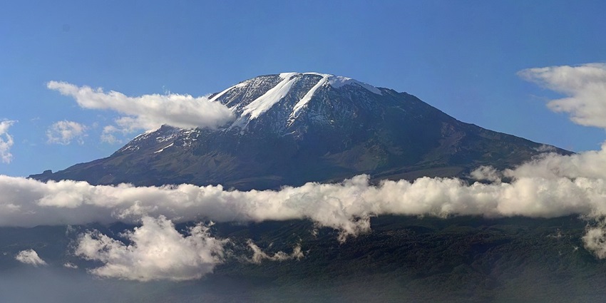 Layers of clouds floating at giant Mount Kilimanjaro - one of the things to do in Tanzania.