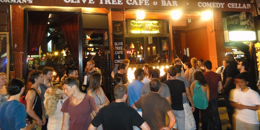 People enjoying a comedy show at the Comedy Cellar celebrating the best New Year party in New York.