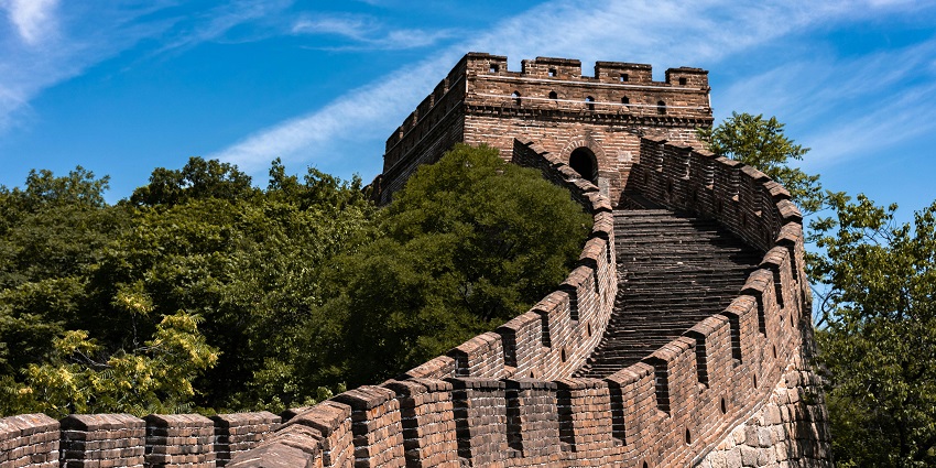 Image of the Great Wall of China through the lush green mountains