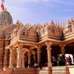 A view of Dwarkadheesh temple that showcases bright colours with a high pillar.