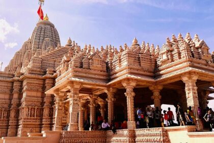 A view of Dwarkadheesh temple that showcases bright colours with a high pillar.