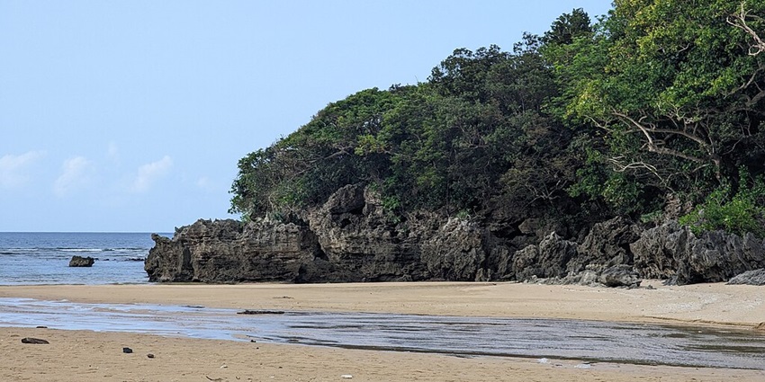 A scenic view of Crystal Beach with calm waves, and a cloudy blue sky, a popular place.