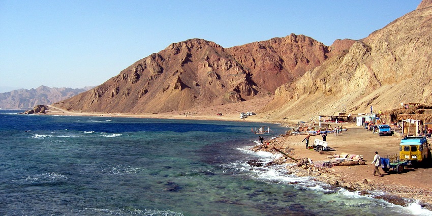 An aerial view of the blue hole in Dahab on the shoreside of which people are present
