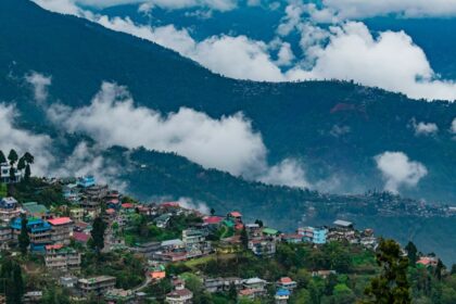 A wide view of Darjeeling shows a massive Kanchenjunga mountain in the background.