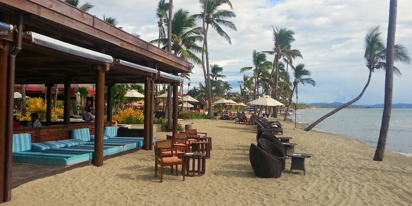 Several chairs of various shapes and beach beds are placed for people to relax at the beach