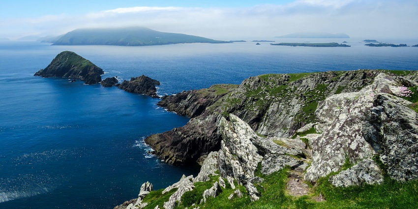 An image of Dingle Peninsula’s coastline with green hills overlooking the ocean.