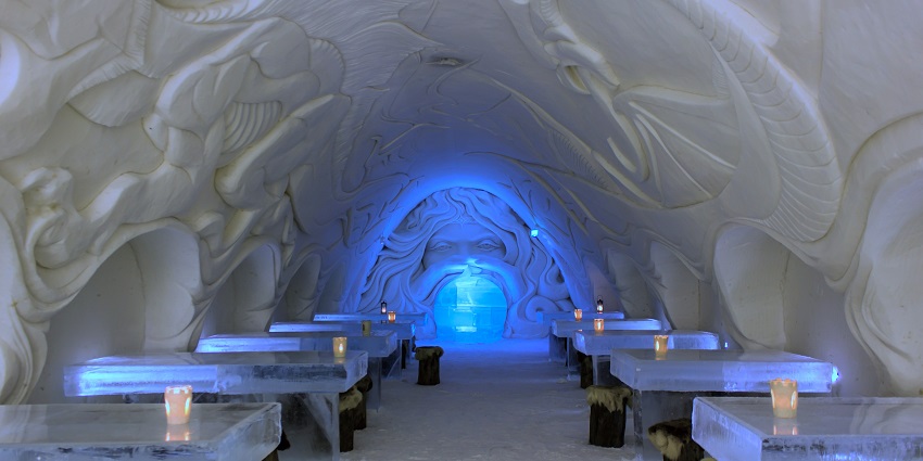 Inside the halls of the Snowcastle of Kemi, with candles set on the ice tables for dinner