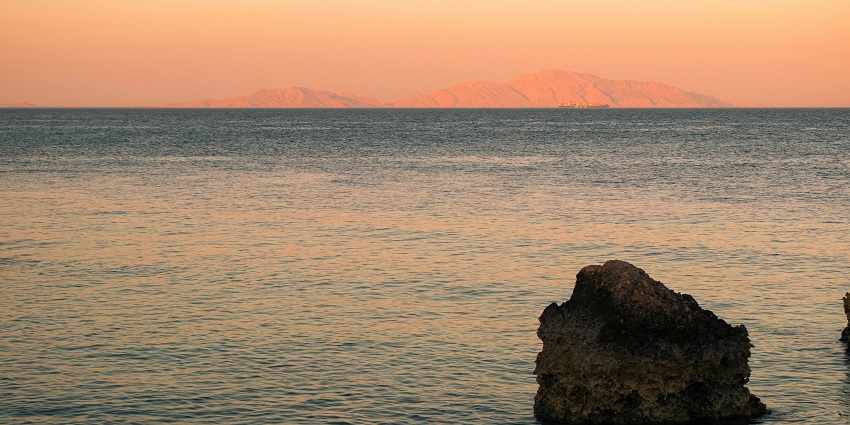 A sunset view by the Red Sea in Sharm El Sheikh with a backdrop of far-away mountains