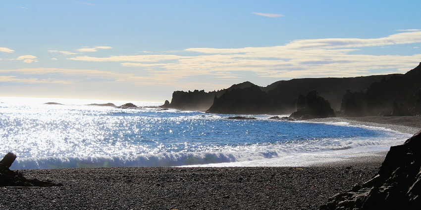 An image of Djúpalónssandur Beach in Iceland, with black sand and a rough coastline.
