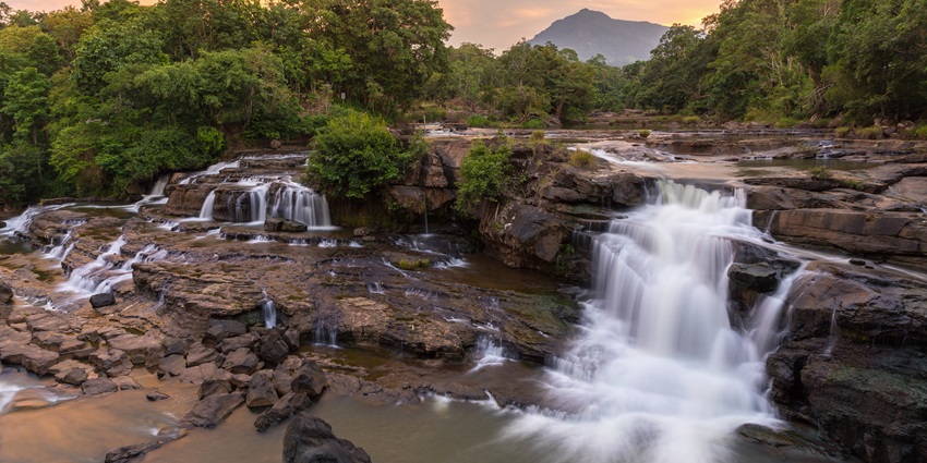 Hidden cascade with turquoise pools, forested backdrop, and seasonal flow ideal for photography and nature walks.