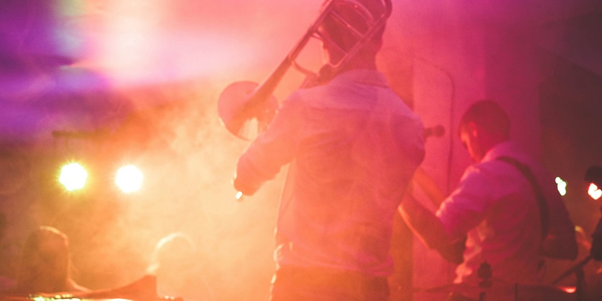 Image of a group of musicians performing on stage with their music instruments