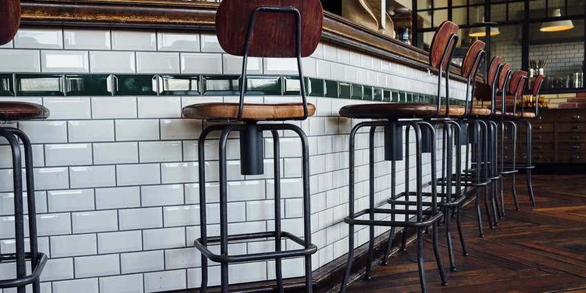 Interior of a bar with stools, wooden counters, and a cosy pub-like atmosphere