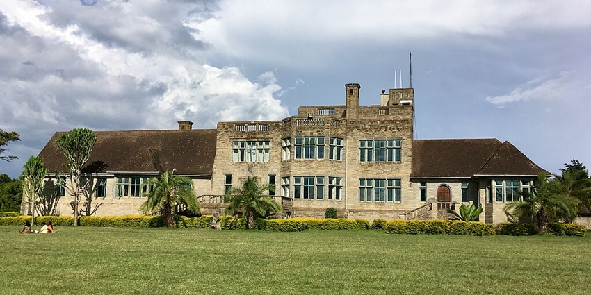 Outside Lord Egerton castle with its historic structure and people sitting on the ground