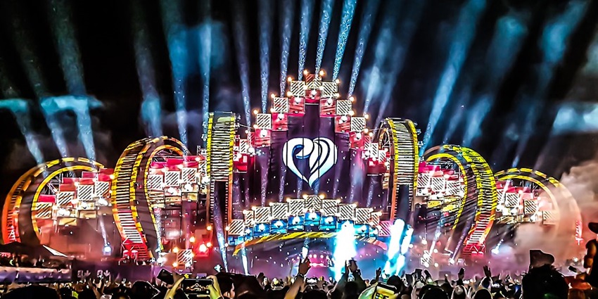 A vibrant image of the Electric Love Festival, showcasing a massive stage with dazzling lights