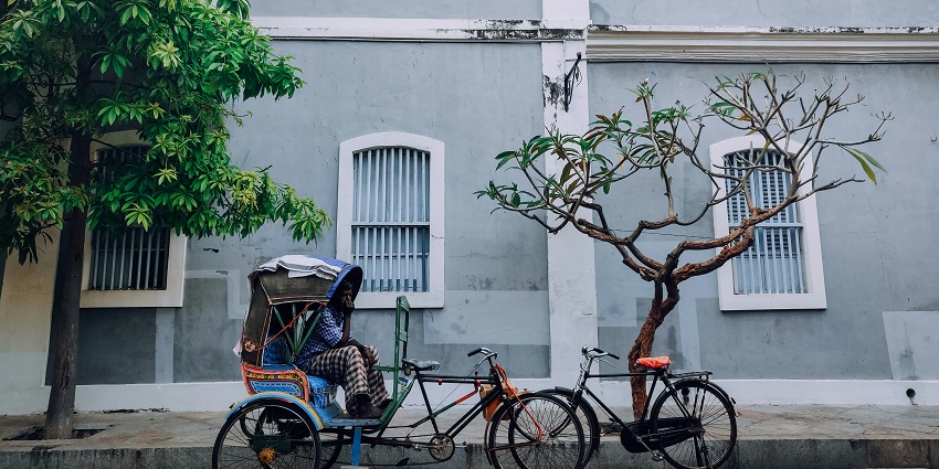 Image of a rickshaw driver sitting on his Rikshaw in Bangladesh
