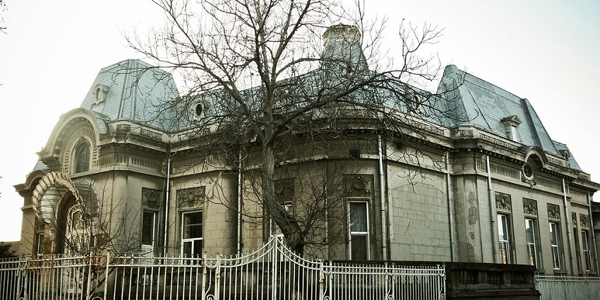 A haunted house wears a spooky look, with a dried tree enhancing the horror atmosphere.