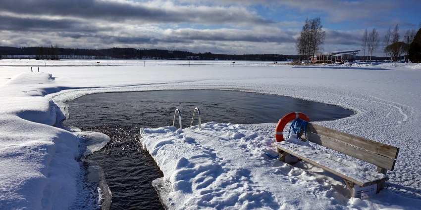 Public Ice swimming pool in snow for avanto swimming with a wooden bench and a tube