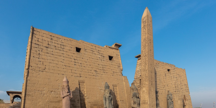 Obelisks of the Luxor temple with detailed carvings and multiple statues in the front
