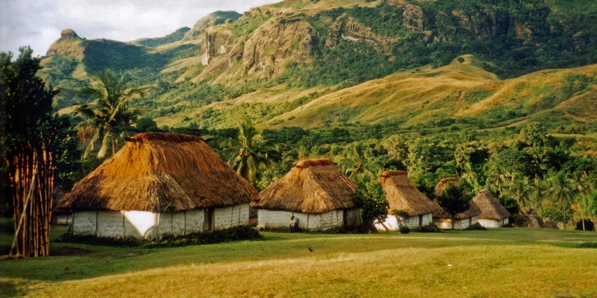 Traditional huts made from straws with a scenic backdrop in the Navala Village, Fiji.