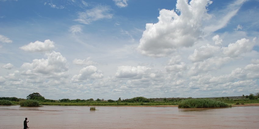 A man standing on the shallow water of the Galana River spread on the Tsavo East Park.