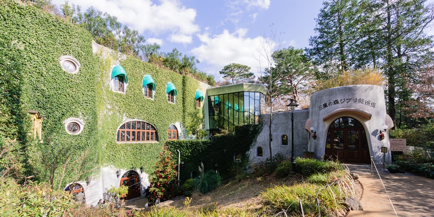 View of the buildings in the Ghibli Museum surrounded by greenery
