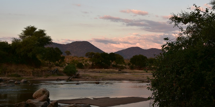 Landscape of the great Ruaha River in the evening with rocks and hills at a distance