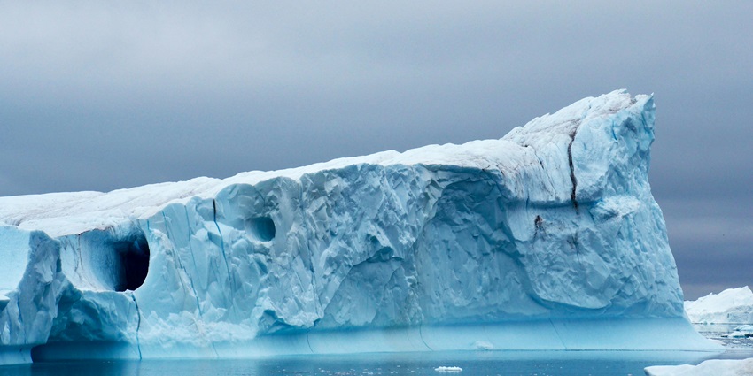 An aerial view of the glaciers flowing through snow-covered landscape in Greenland.