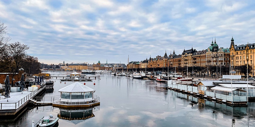 Blockhusudden side on the Djurgarden island with villas surrounded by greenery and lake.