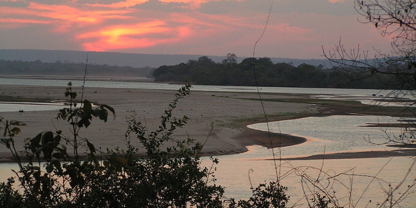 Rufiji River at Selous National Park Tanzania with sandy shores in between and distant greenery.